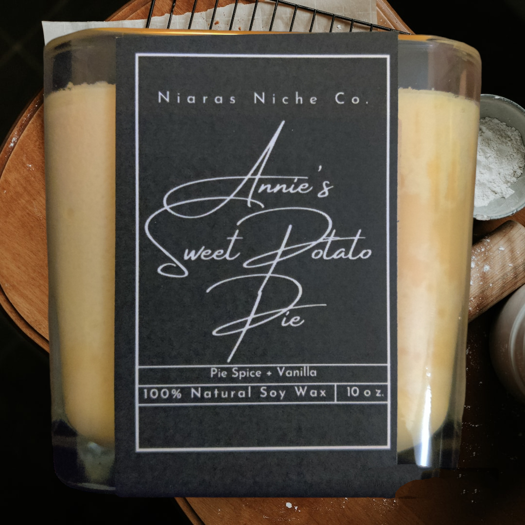 Niaras Niche Co. candle labeled 'Annie's Sweet Potato Pie' in black packaging, featuring pie spice and vanilla scents.