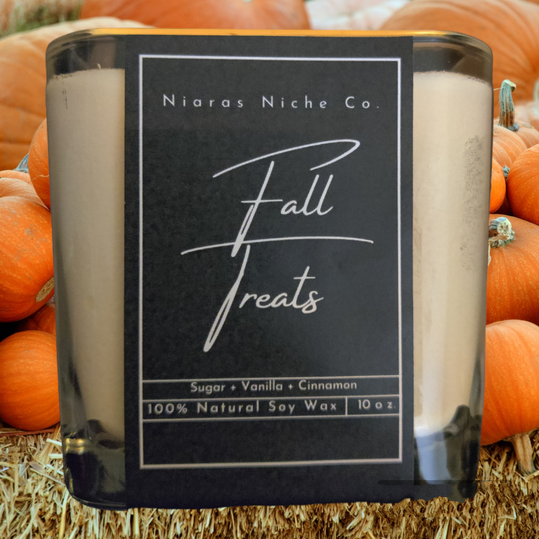 Niaras Niche Co. Fall Treats candle, 10 oz, natural soy wax, infused with sugar, vanilla, and cinnamon, set against pumpkins.