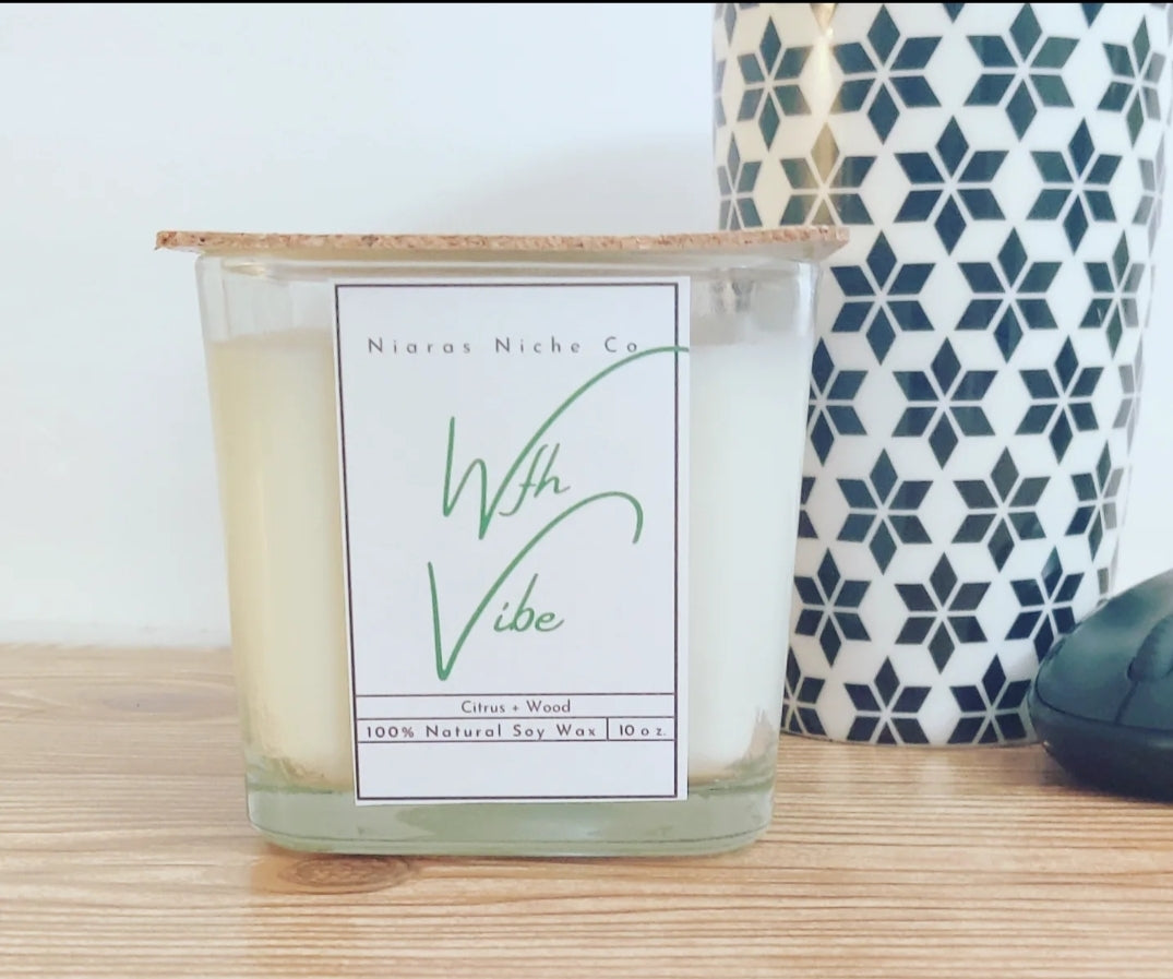 Niaras Niche Co. "With Vibe" Citrus & Wood 10 oz. soy wax candle in a clear glass container with a cork lid.